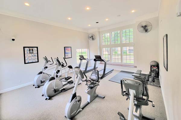 Fitness center with two large TVs, a free weight area, and tons of cardio machines.
