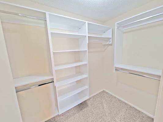 Bedroom with overhead ceiling fan and walk-in closet. Comfortably fits a queen size bed.
